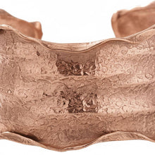 Load image into Gallery viewer, a close-up view of a textured, metallic bracelet with a reddish-brown hue. The bracelet appears to be made of copper or brass and has a distinctive, wavy pattern.