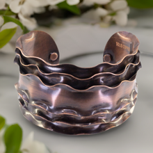 Load image into Gallery viewer, a close up of a metal object with flowers in the background