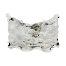 Load image into Gallery viewer, A silver bracelet with a unique, textured design.
