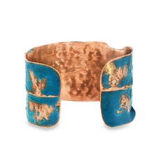 Load image into Gallery viewer, A copper bracelet with blue and brown hues, featuring a textured pattern.
