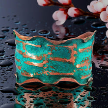 Load image into Gallery viewer, A vibrant turquoise-colored cuff bracelet with a textured pattern sits on a reflective surface, surrounded by water droplets.
