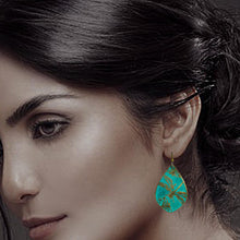 Load image into Gallery viewer, A close-up of a woman's face, with her hair styled in a bun and a teal-colored earring hanging from her ear.
