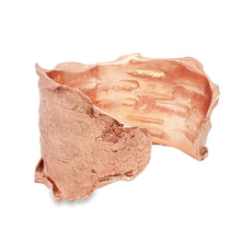 Load image into Gallery viewer, a copper-colored bracelet with a textured, organic shape.
