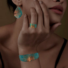 Load image into Gallery viewer, A close-up of a woman&#39;s face, showcasing her hand adorned with a ring and bracelet, and a pair of earrings featuring a sunflower design.
