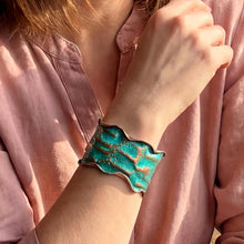 Load image into Gallery viewer, A close-up of a person's wrist wearing a turquoise-colored, textured bracelet.
