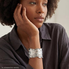 Load image into Gallery viewer, A woman with curly hair wearing a gray shirt and a silver cuff bracelet is looking off to the side.
