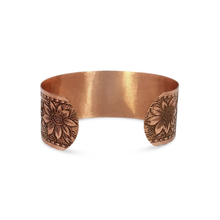 Load image into Gallery viewer, A copper-colored bracelet with a floral design on the clasp.
