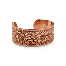 Load image into Gallery viewer, a copper bracelet with an intricate floral design.
