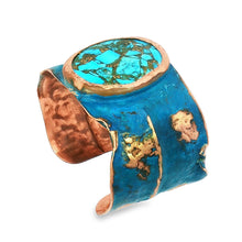 Load image into Gallery viewer, a piece of jewelry with a blue and copper color scheme. The piece appears to be a bracelet or cuff, with a large turquoise stone or gemstone at the center. The design is intricate and detailed, showcasing the craftsmanship of the piece.
