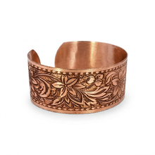 Load image into Gallery viewer, a copper bracelet with an intricate floral design.

