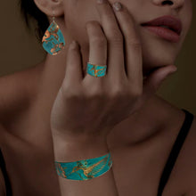 Load image into Gallery viewer, A close-up of a woman&#39;s hand wearing a ring and bracelet with a bird design, and a pair of earrings with a bird design.
