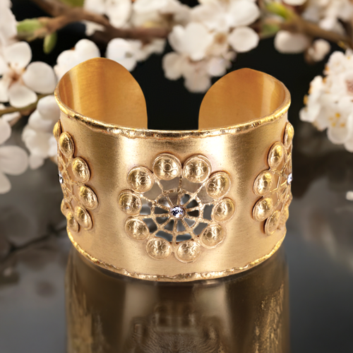 a close up of a gold bracelet on a table